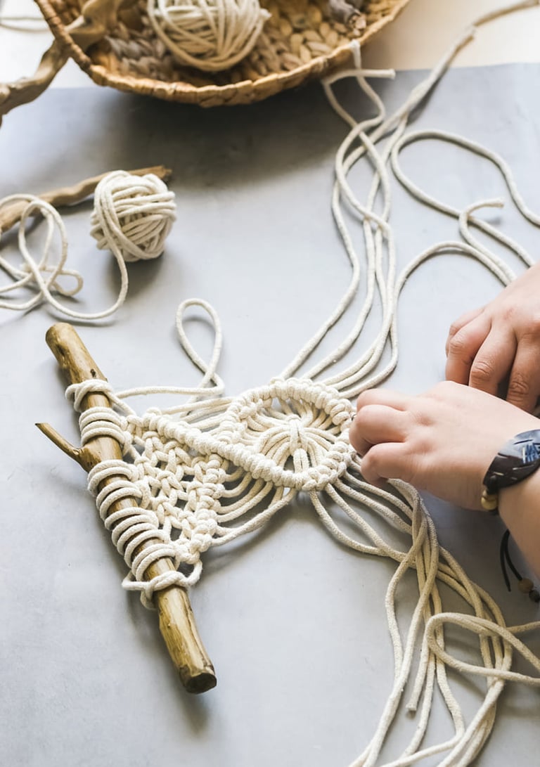Manos creando un tapiz decorativo de macramé hecho a mano (DIY) utilizando cuerda de algodón natural