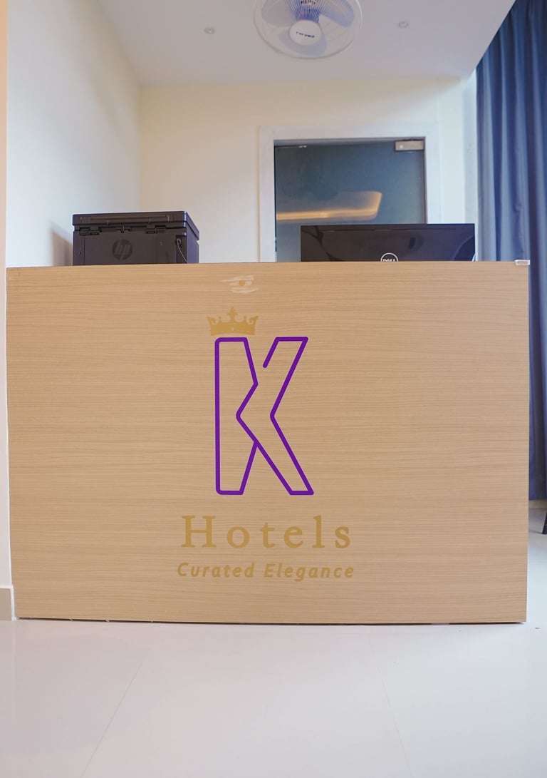 Modern hotel reception desk with K Hotels branding and elegant minimalist interior design.