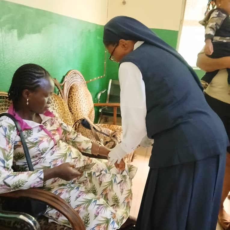 A catholic nun nurse providing medical care to a patient at a community health clinic.