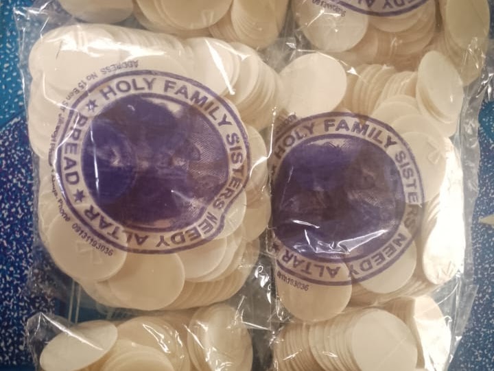 Stacks of white altar bread communion wafers in plastic bags from Holy Family Sisters.