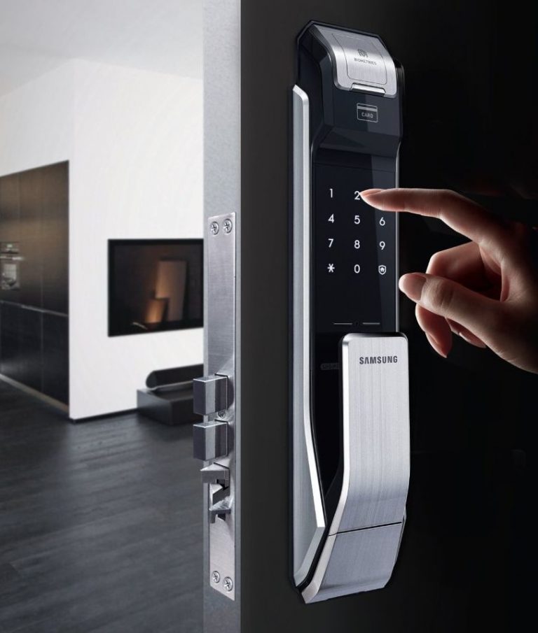 a person's hand is pressing a keypad on a door