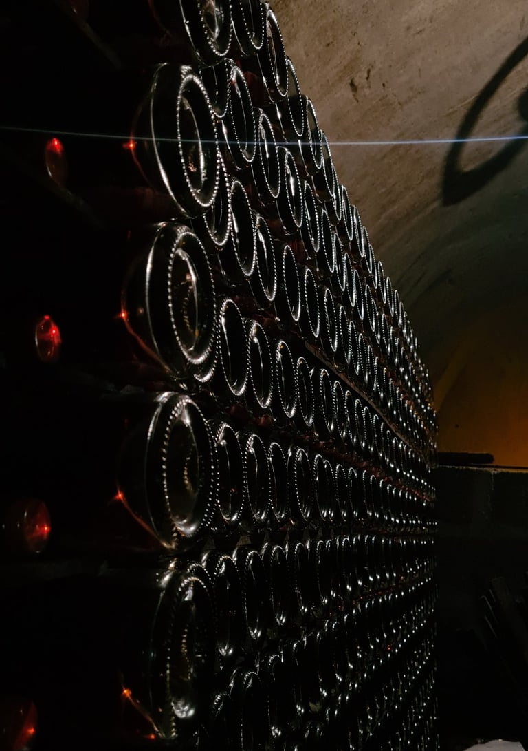 Atmospheric view of champagne bottles aging in a historic underground cellar, captured in dramatic low light.