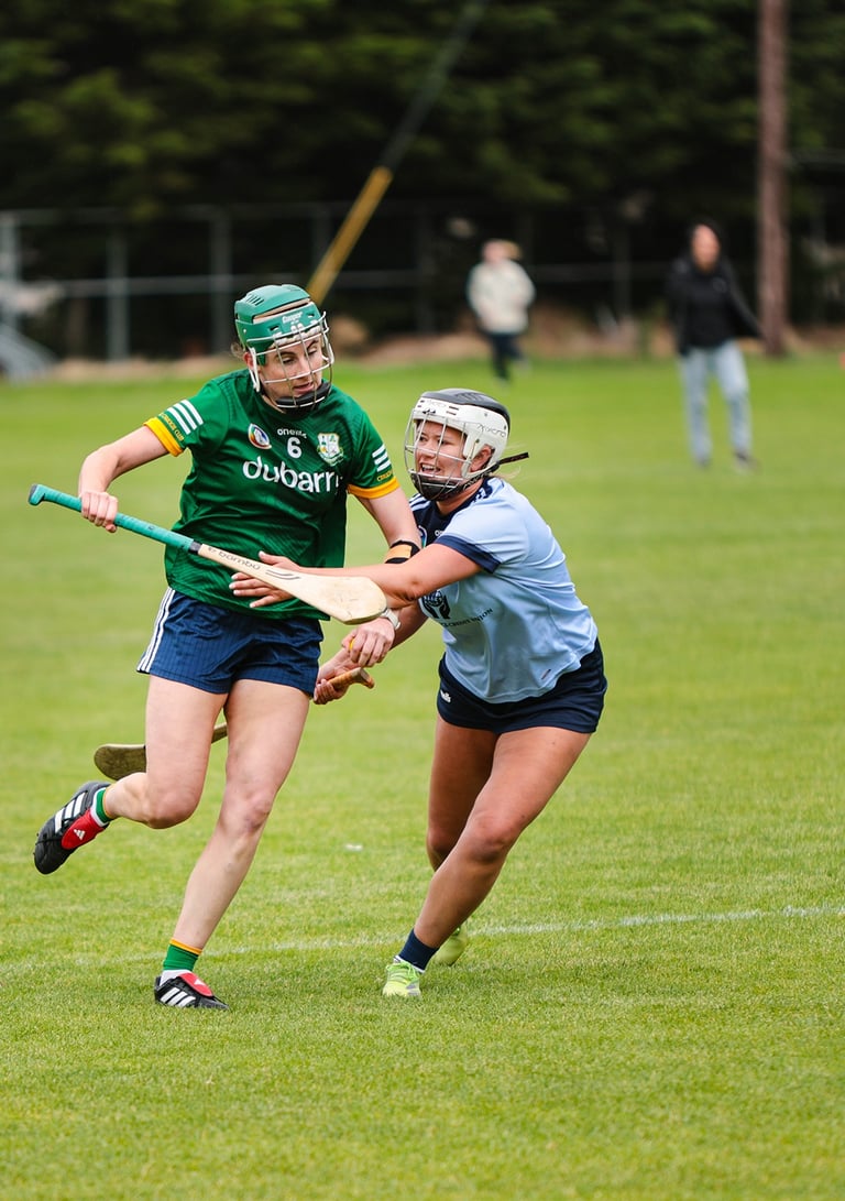 Camogie player breaking through a tackle