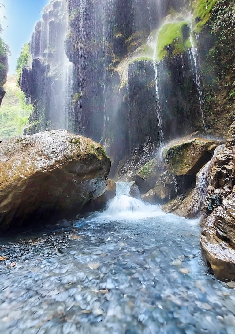 Umbrella waterfall in a canyon with a waterfall in the background