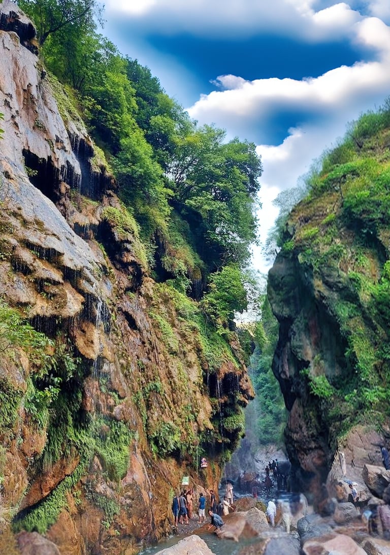 a group of people standing on a mountain side at umbrella waterfall 