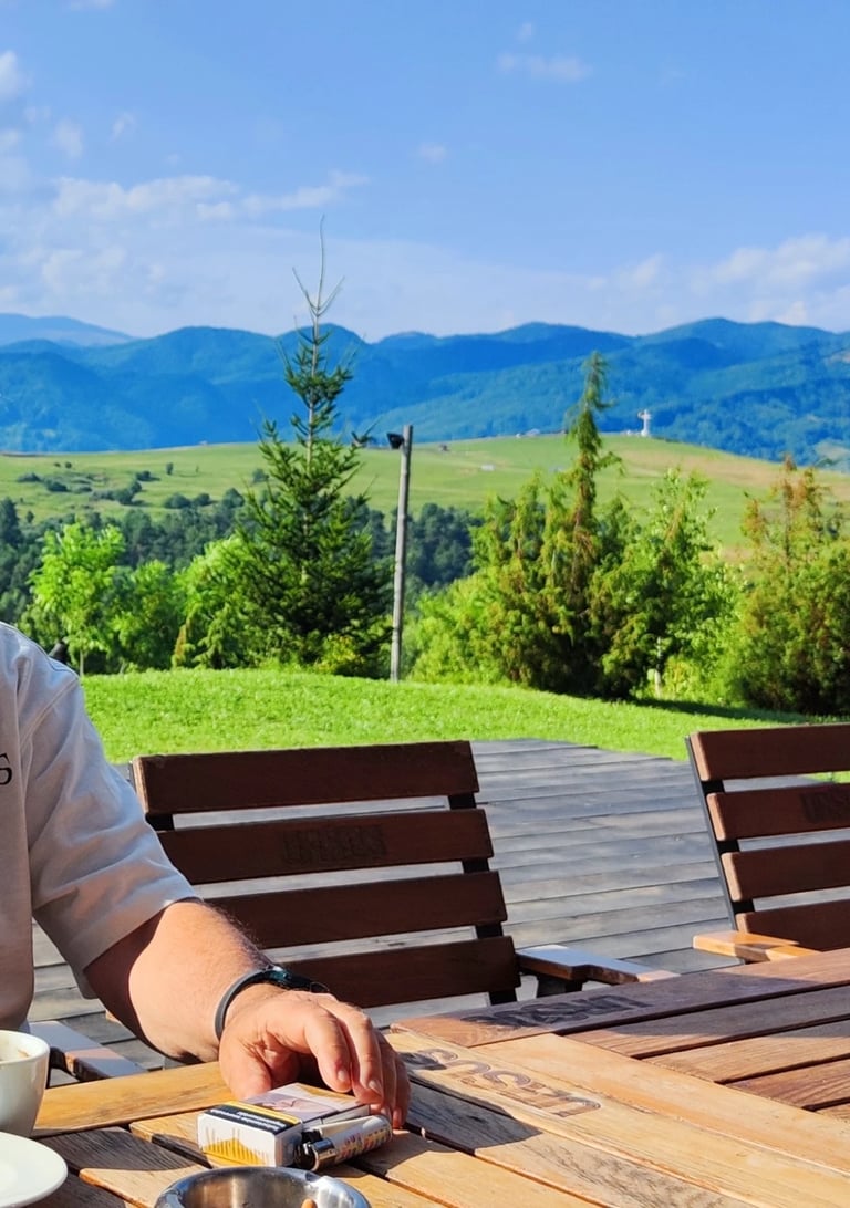 a man sitting at a table with a cup of coffee