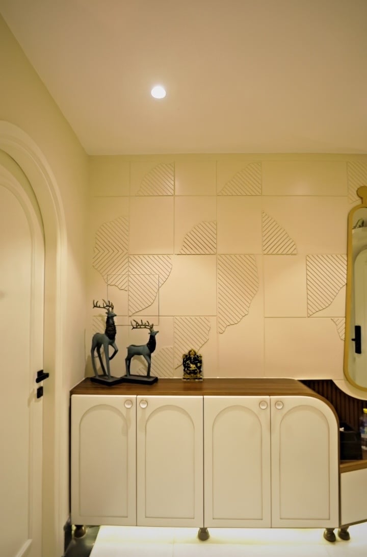 Modern home entryway featuring a white storage cabinet with deer figurines and textured wall paneling.