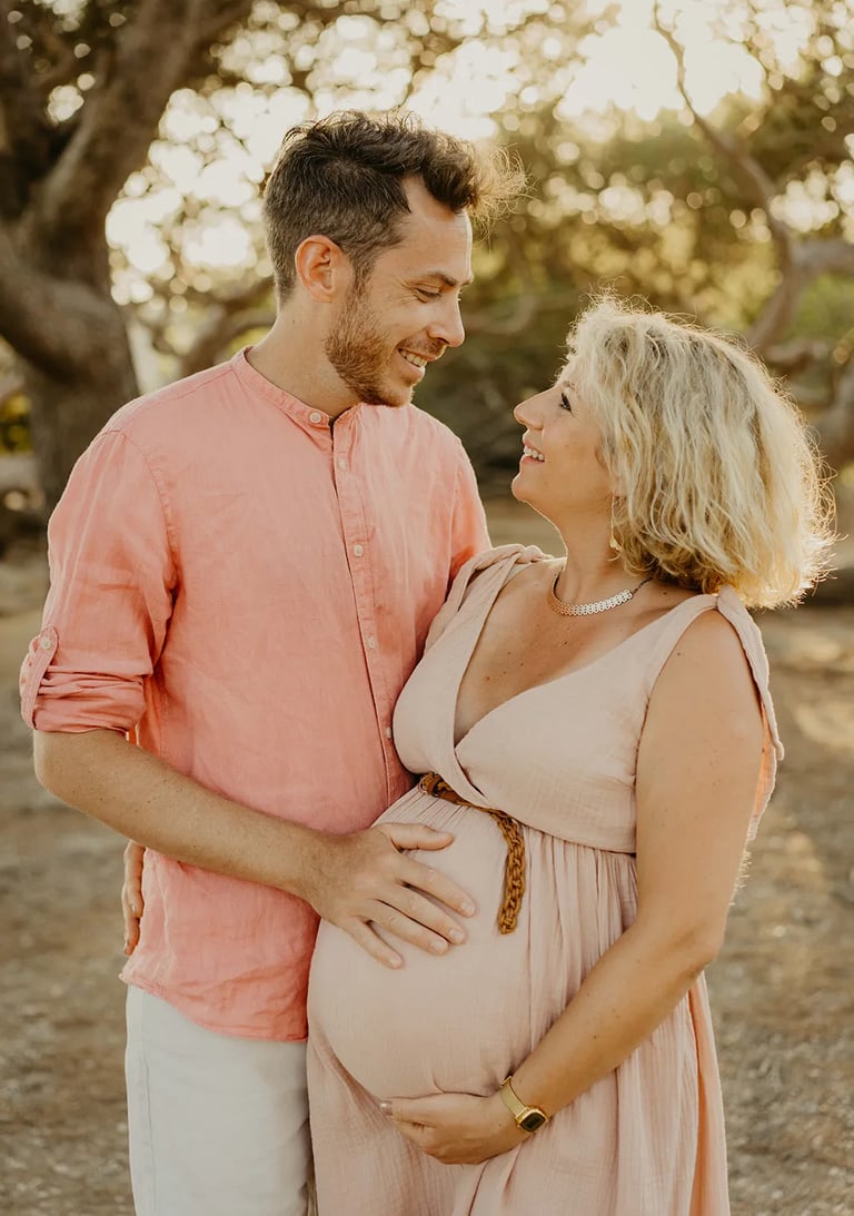 Couple qui se regarde tendrement au coucher du soleil – séance photo grossesse en extérieur Gard