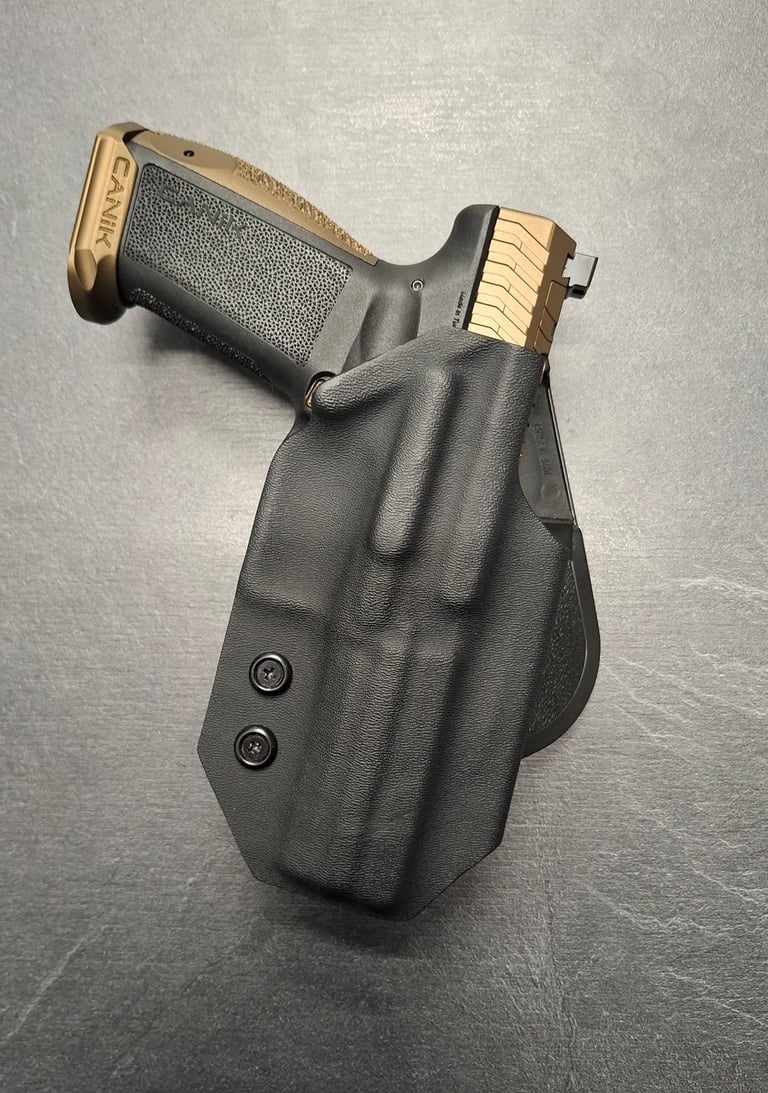 Canik TP9 pistol with gold accents secured in a black Kydex IWB holster for concealed carry.