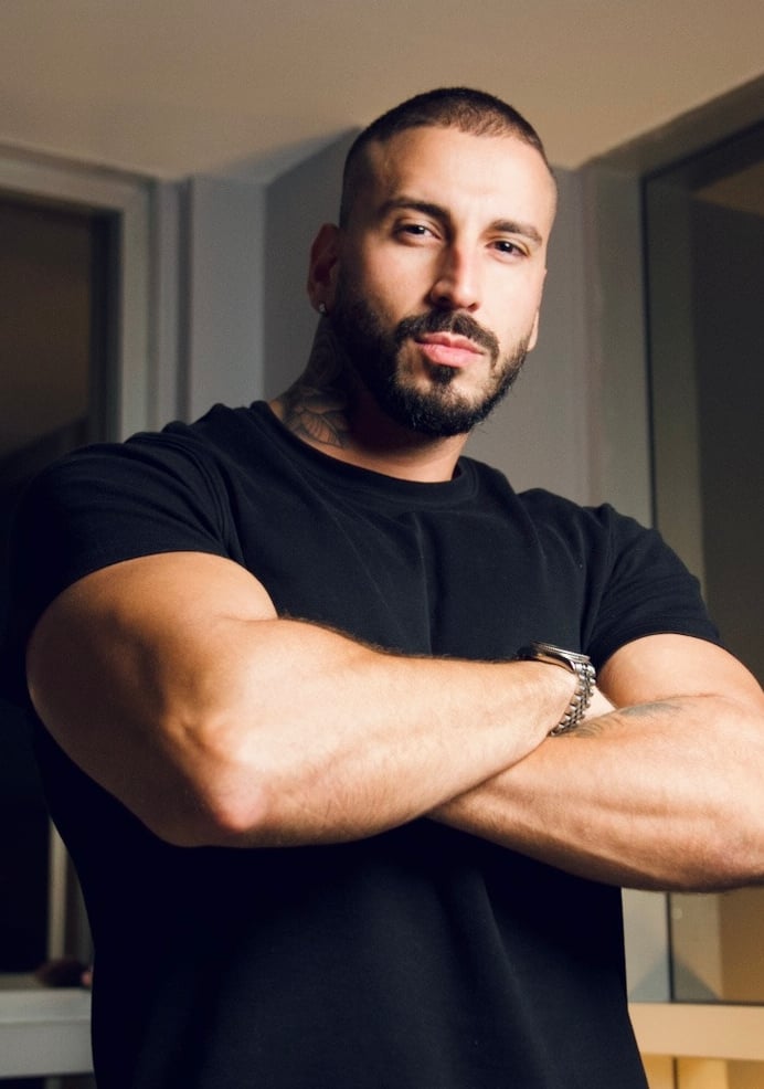 a man with a beard and a beard, standing in front of a mirror