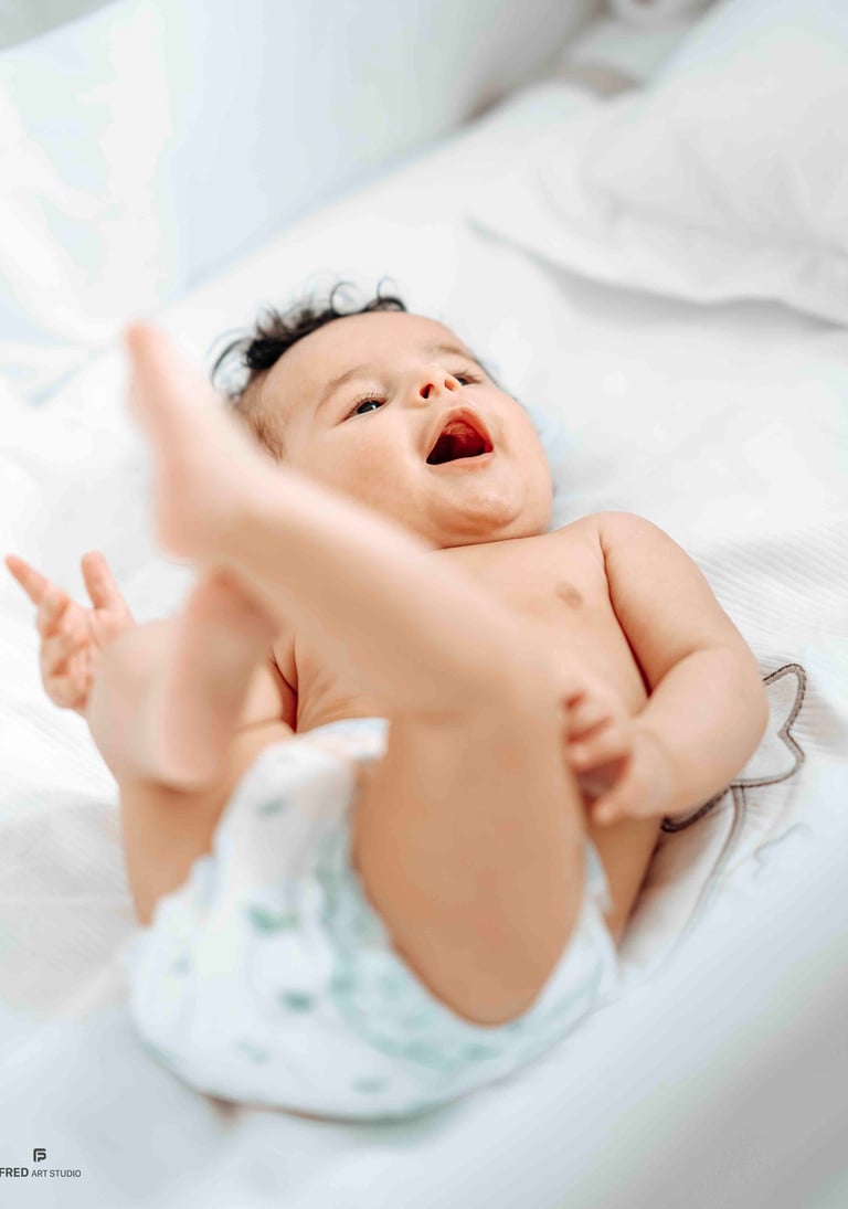 Smiling baby lying on bed – Fred Art Studio family session