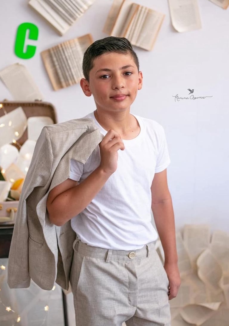un niños adolescente con un traje de lino beige celebrando su graduación