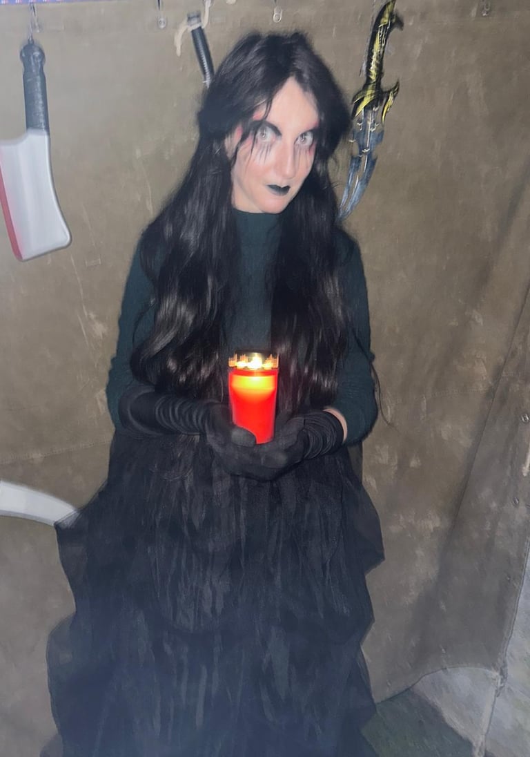 a woman in a black dress holding a candle