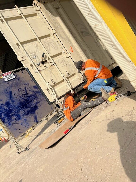 Technicians working on a container preforming service work for a mobile service call.