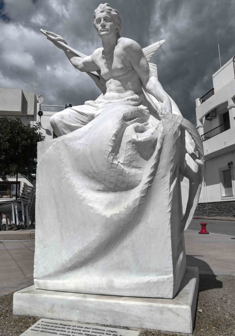 White marble sculpture depicting a fisherman holding a swordfish under a cloudy sky in Carboneras.