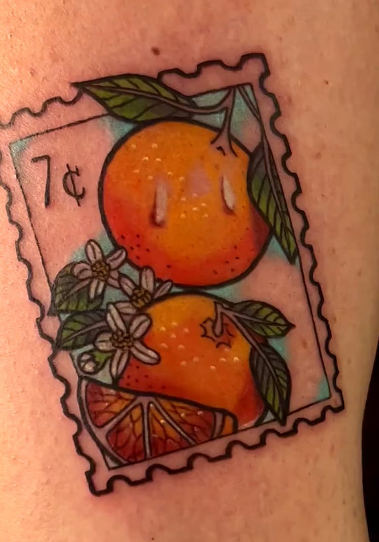 Vintage postage stamp tattoo featuring oranges, citrus blossoms, and a 7 cent mark.
