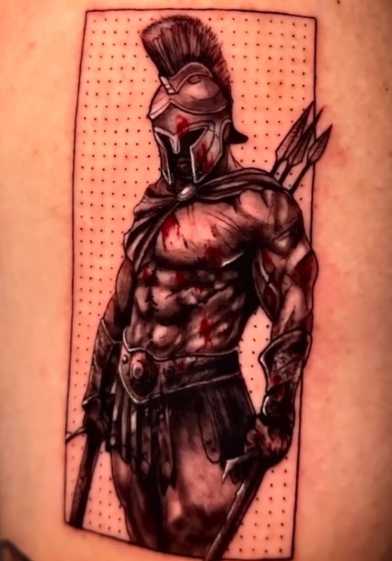 Detailed Spartan warrior tattoo with helmet, spear, and blood splatter on skin.