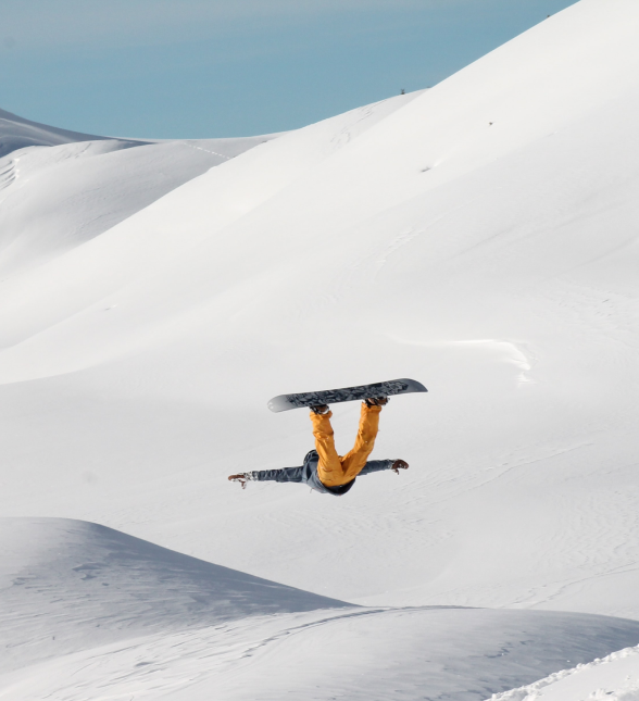 a snowboarder doing a trick on a snowy mountain