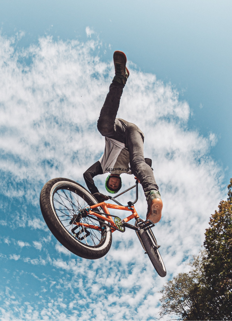 a man doing tricks on a bicycle in the air