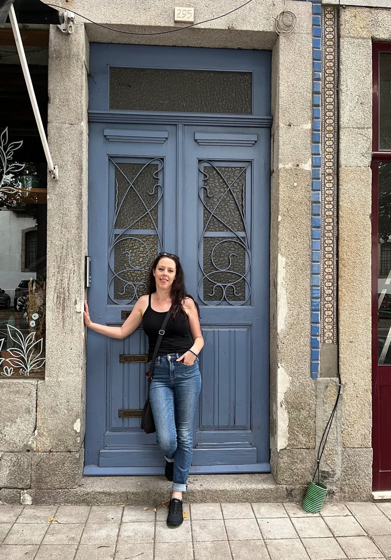 a woman standing in front of a blue door