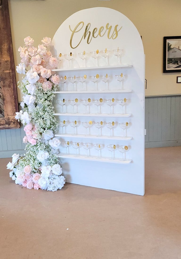 White champagne with a pink and white floral arrangement and champagne flutes