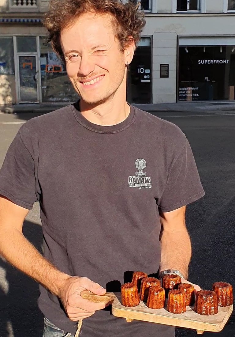 Un homme tient une planche avec des cannelés dessus