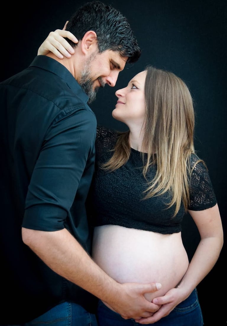 photo de grossesse maternité d'un couple sur fond noir 