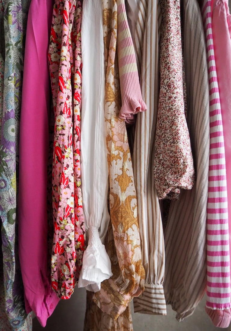 Kolorowe ubrania wiszą na wieszakach