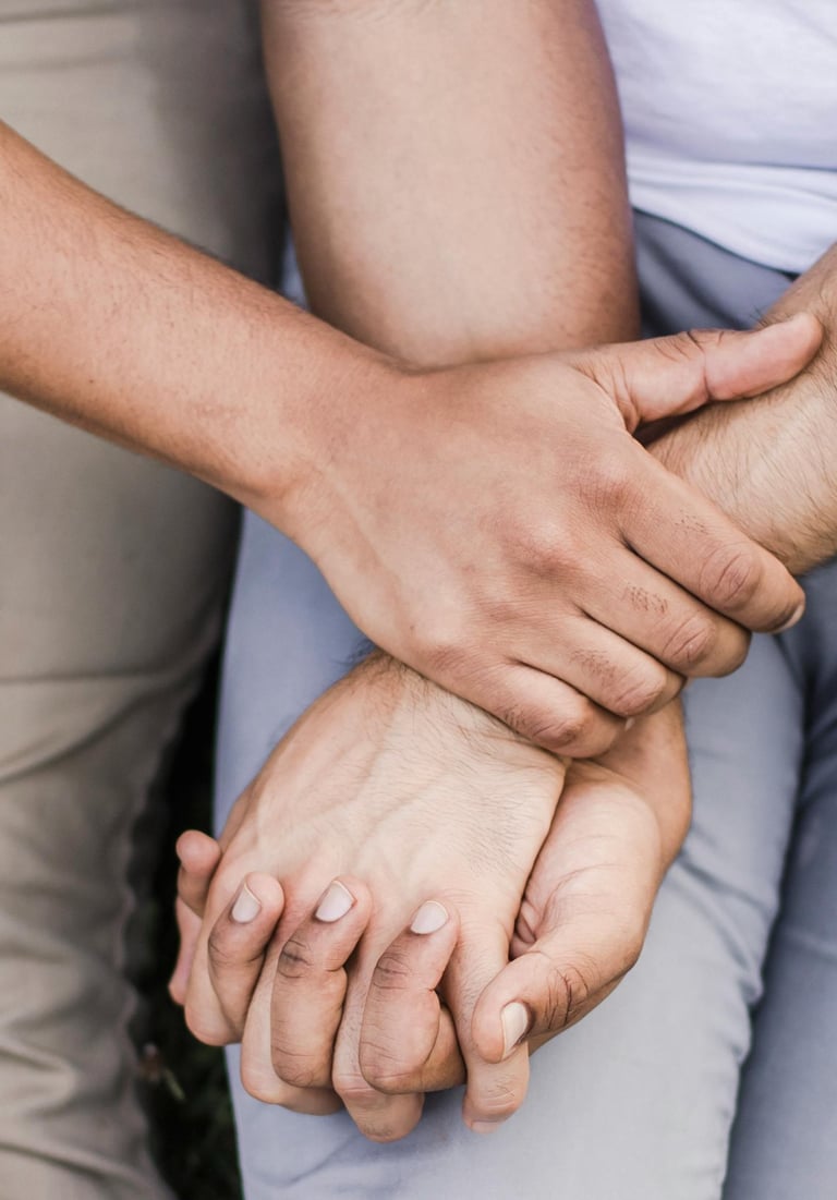 Close-up of a diverse couple holding hands and offering emotional support with a gentle touch.