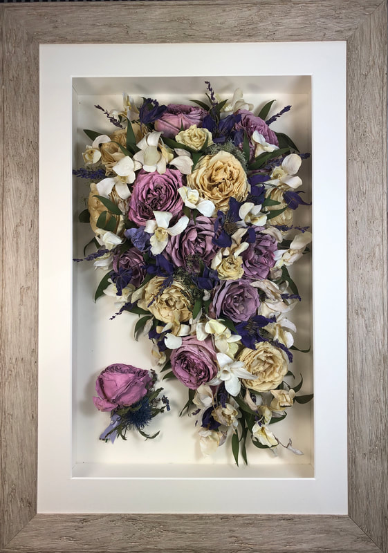 a purple trailing view preserved wedding bouquet with buttonhole in a frame
