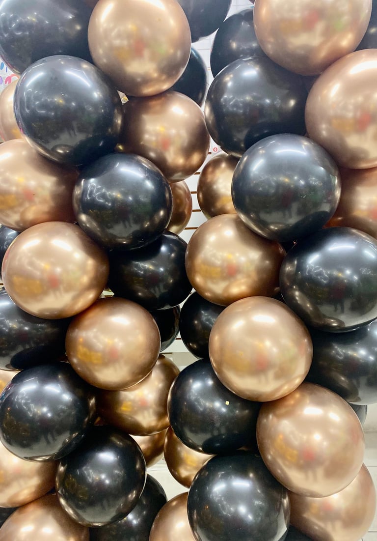 Columnas de globos cromados dorados y globos negros metalicos