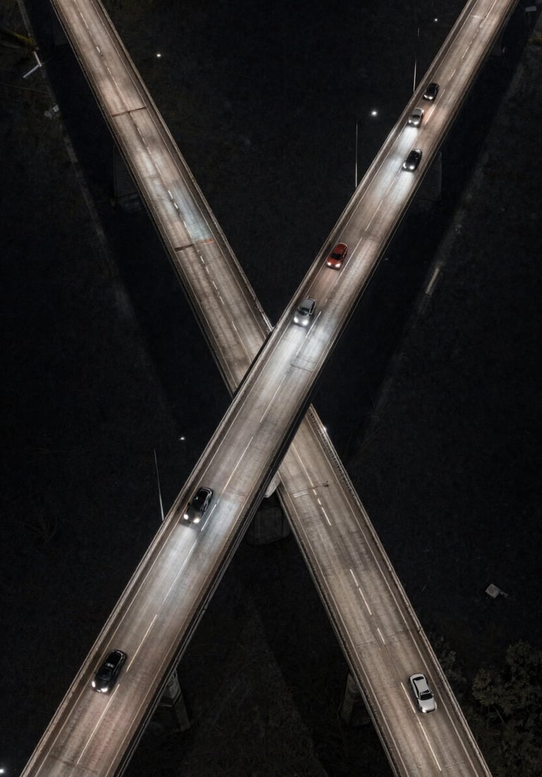 An aerial shot of a North American bridge at night, car headlights forming streaks of light. The composition is cinematic and expansive, using charcoal and off-white tones.