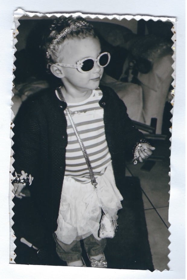 Black and white photo of young girl in extravagant fancy dress