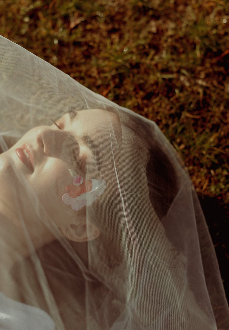 portrait rapproché d'un visage féminin maquillé recouvert d'un voile en tulle transparent