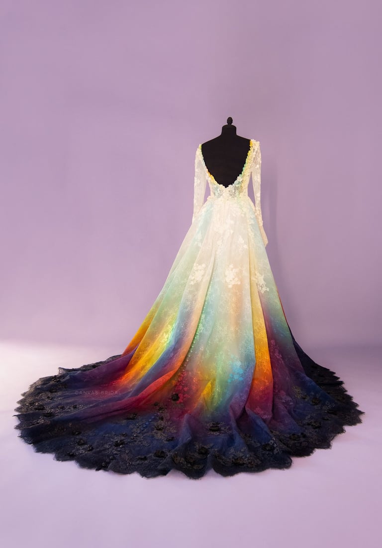 A lace wedding dress the fades from white into a rainbow of colors then into black.