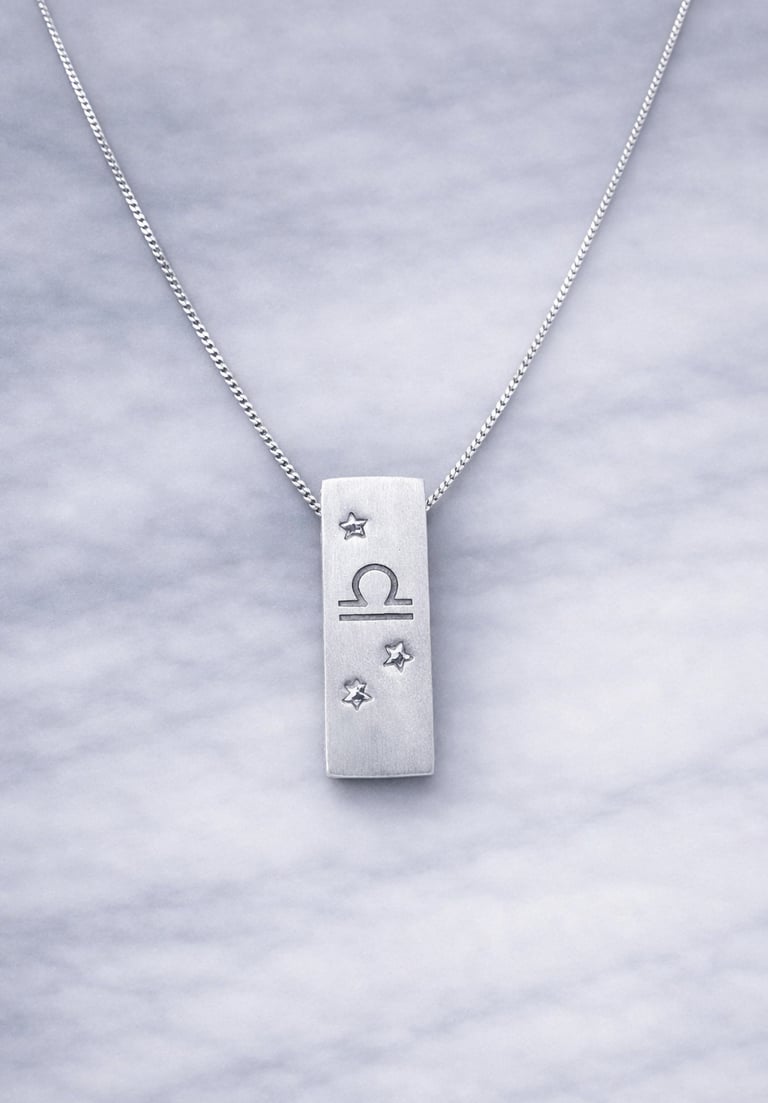 Handmade 999 silver Libra zodiac necklace with a vertical bar pendant on a marble surface.