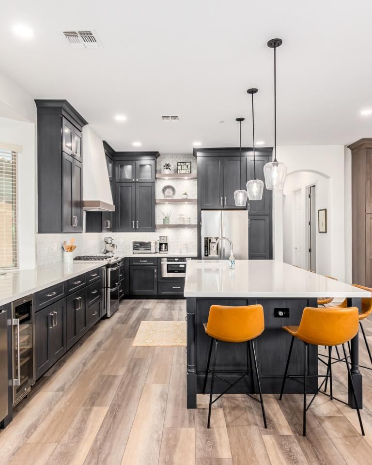 "Custom kitchen design with white quartz countertops, wood accents, and stainless steel finishes"