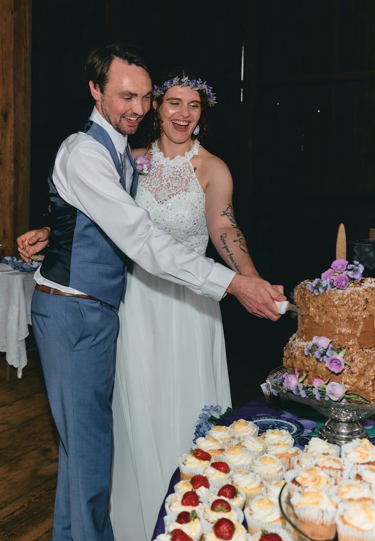 a bride and groom are cutting into a wedding cake
