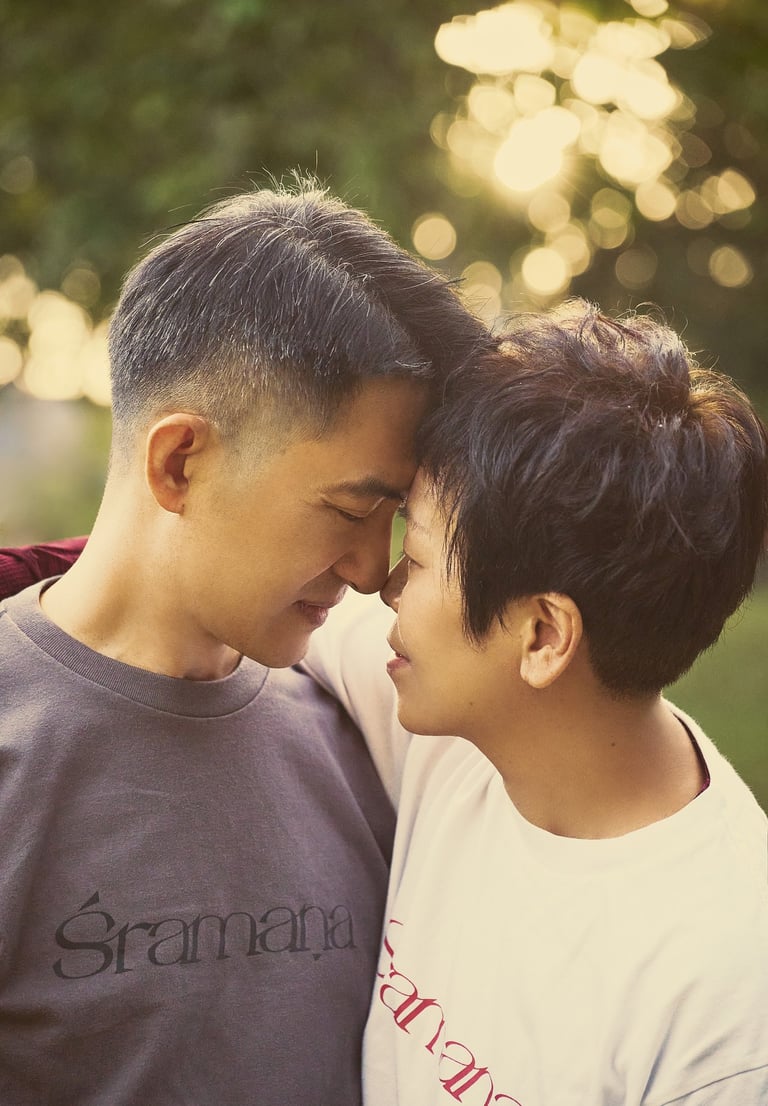 Happy Asian couple touching foreheads during a romantic outdoor sunset date.