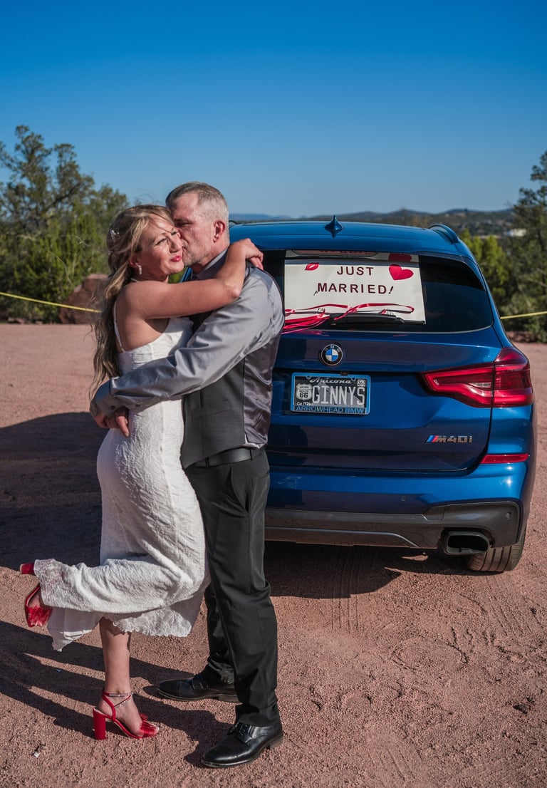 a man and woman standing in front of a car