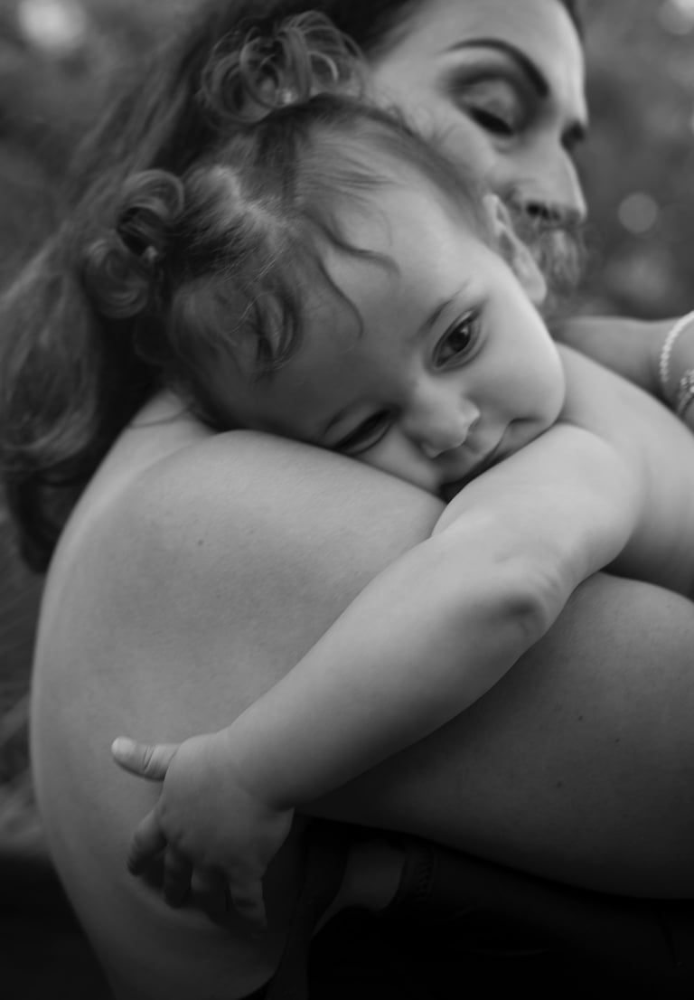 black and white image of mother holding her baby on the arms in the intimate moment