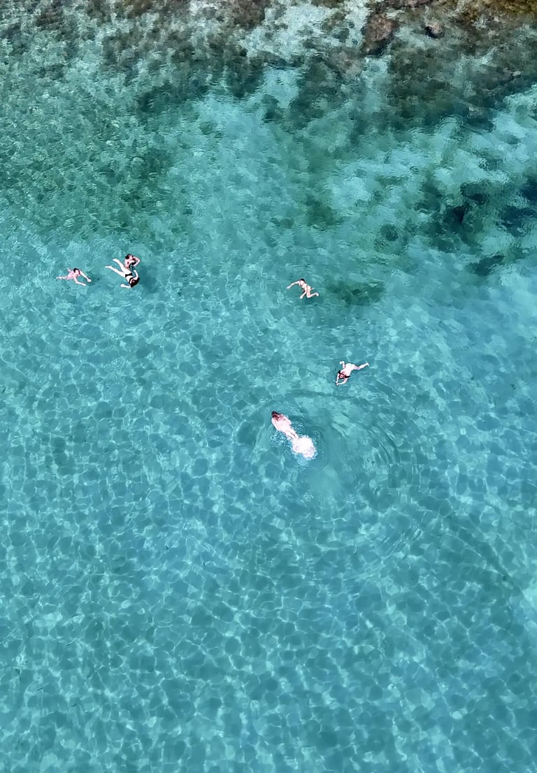 Aerial view of girls swimming and snorkeling in a bay near Milna on Brac during a private boat tour from Split, Croatia