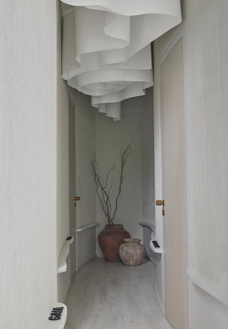 Modern minimalist hallway design with curved walls and artistic ceiling installation