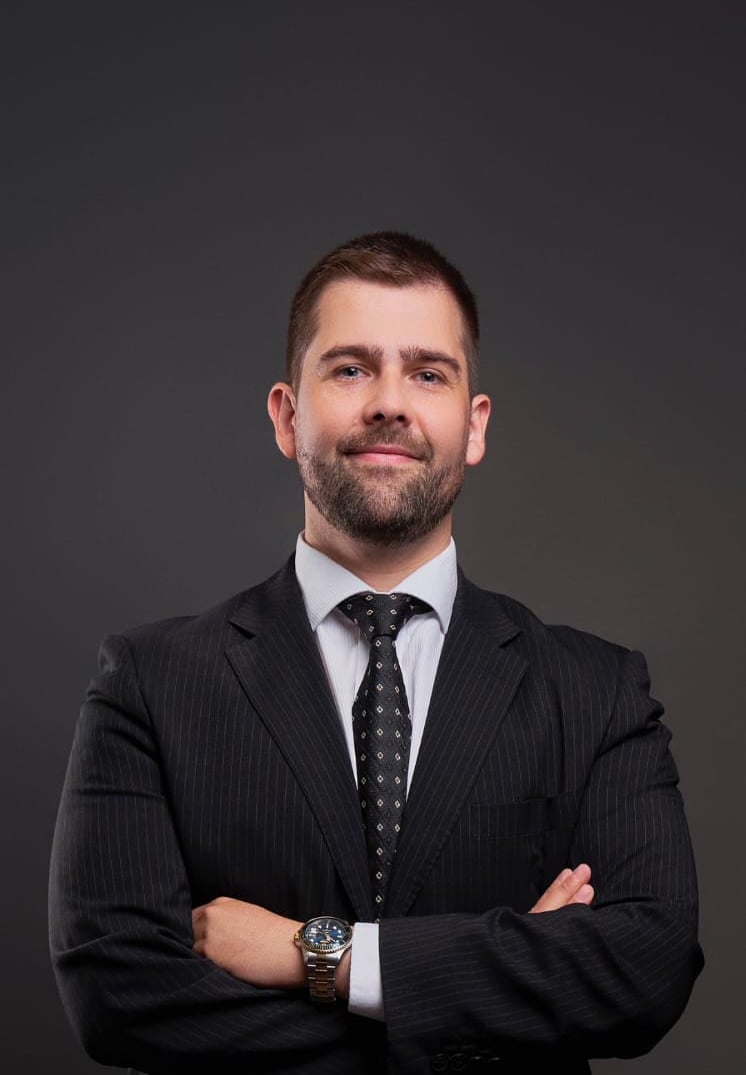 a man in a suit and tie with a watch on his wrist