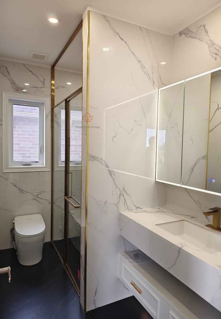 Luxurious white marble bathroom with a frameless shower, modern vanity with gold fixtures, and sleek smart toilet.