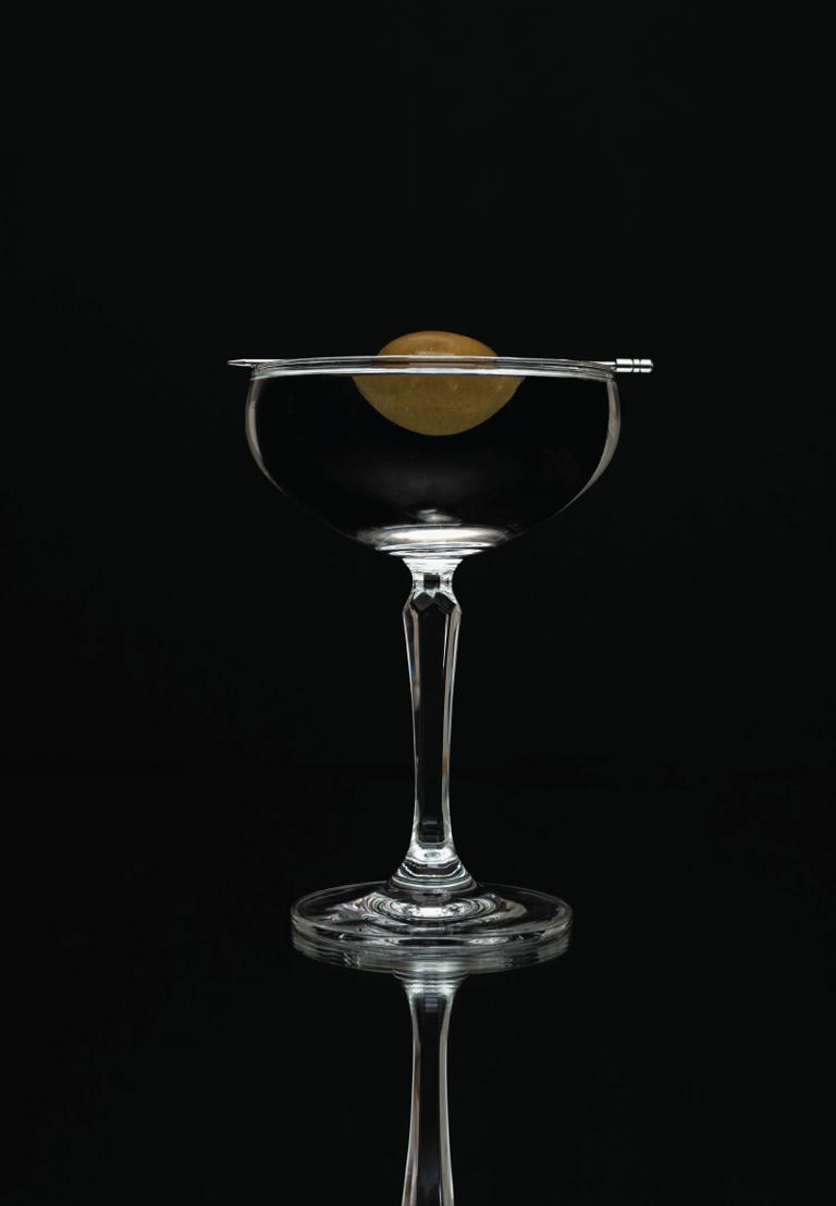 a martini glass with a olive on it