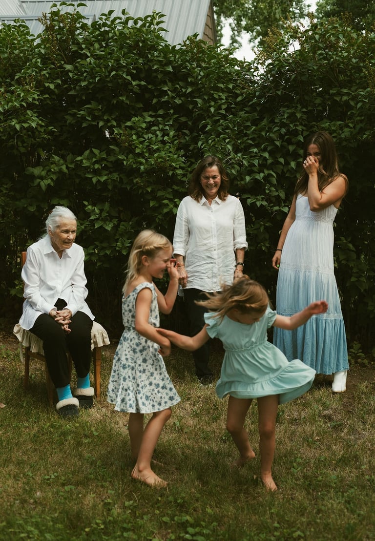 a family gathering in a backyard with a young girl playing with a frisbee