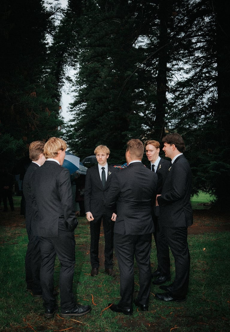 Groomsmen gathering beneath the pine trees before the ceremony at Adelaide Botanic Garden