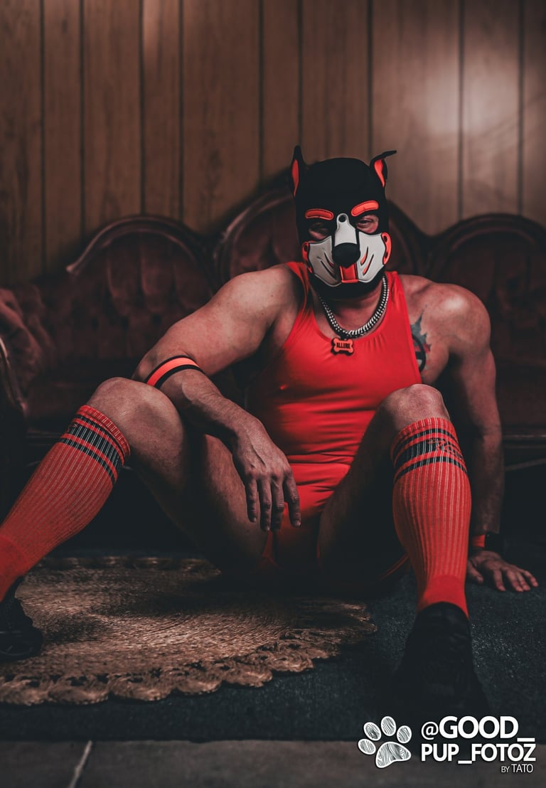 Man in pup mask, posing on the floor.
