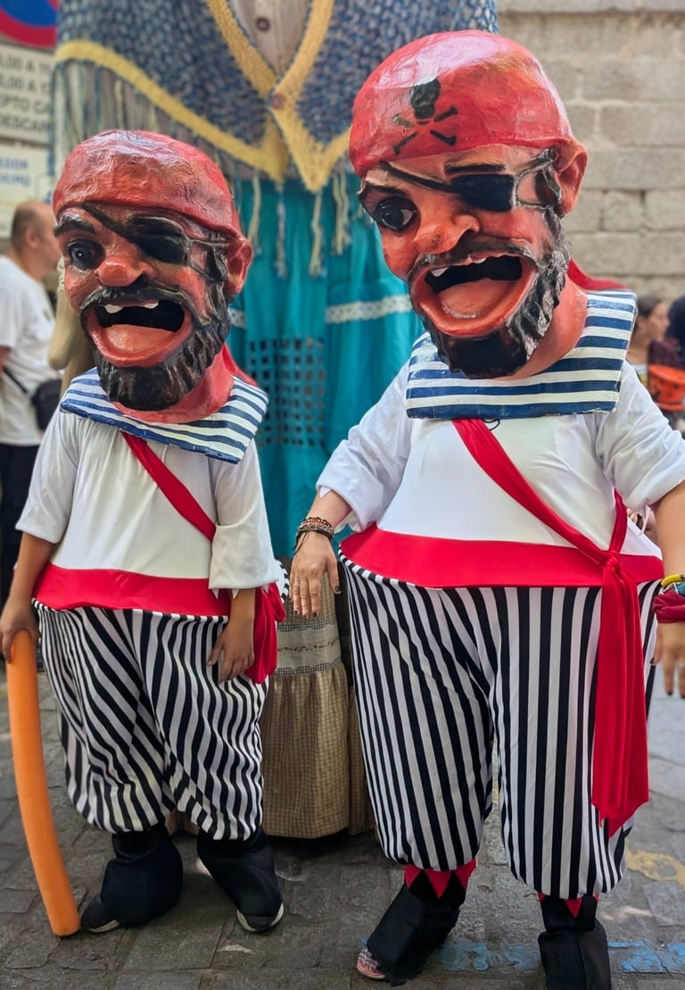two cabezudos in grotesque pirate costumes with large heads